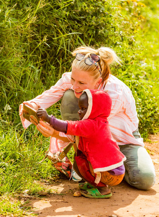 Kathleen in Uganda showing orphan her cell phone