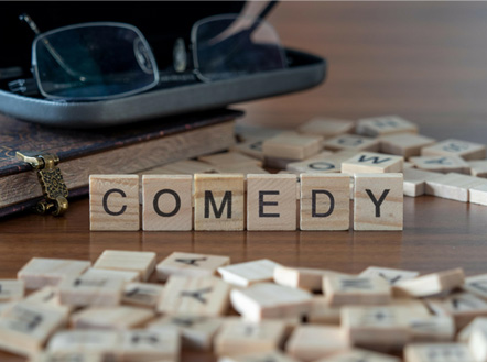 Scrabble letters spelling "Comedy"